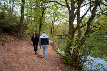 Obraz premium Middle aged couple taking a hike alongside a lake in the spring