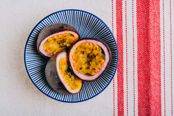Sliced passion fruit in a blue plate in asian style, tropical concept.