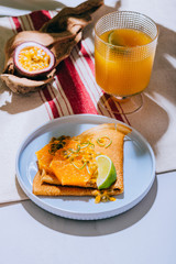 Crepes Or Thin Pancakes With Delicious passion fruit and lime. A glass with mango nectar. Summer tropical concept.