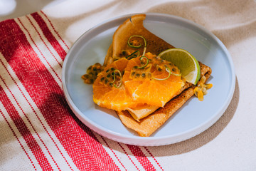 Crepes Or Thin Pancakes With Delicious passion fruit and lime on linen napkin. Summer tropical concept.