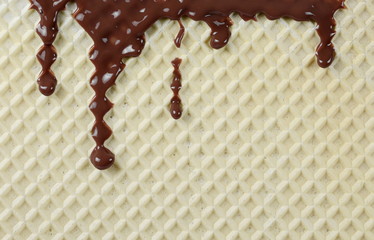 Cream chocolate, topping dripping from wafer, waffle surface background and texture