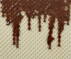 Cream chocolate, topping dripping from wafer, waffle surface background and texture