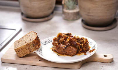 Fototapeta na wymiar Bigos - a traditional Polish dish with bread on a plate
