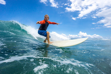 muscular surfer with long white hair riding on big waves on the Indian Ocean island of Mauritius - obrazy, fototapety, plakaty