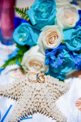 Fototapeta na wymiar Wedding rings close up decorated nautical with accessories for tropical wedding ceremony on the sandy beach in Dominican republic, Punta Cana