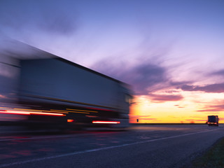 fast truck on the highway in sunset time and in long exposure for increasing speed of moving it under sky with copy space