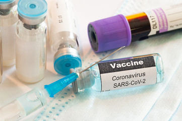 Medical syringe with glass ampoule vial with coronavirus COVID-19 vaccine. Fight of the coronavirus...