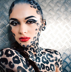 young sexy woman with leopard make up all over body, cat bodyart print closeup