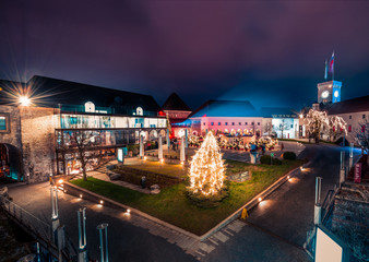 Ljubljana Castle backyard in December, Slovenia. New years lights at night. Christmas tree covered with light. In background castle tower.