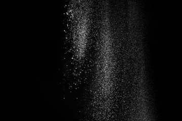 Fototapeta na wymiar White fluffy snow on small particles isolated on black background