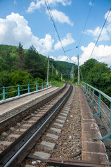 railway leading towards the mountain range against the blue sky. traveling by rail