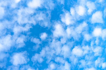Fluffy clouds on bright blue sky background