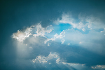 Sunlight breaks through the stormy clouds before the rain.