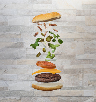 Hamburguesa con ingredientes en el aire