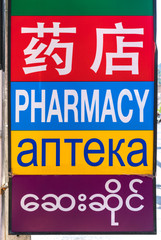 Pharmacy sign hanging on a building on the road