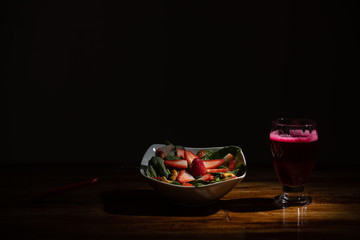 strawberry and spinach salad with beet juice on dark background