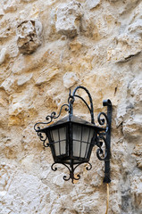 Retro lantern on old stone wall background, Antibes, France