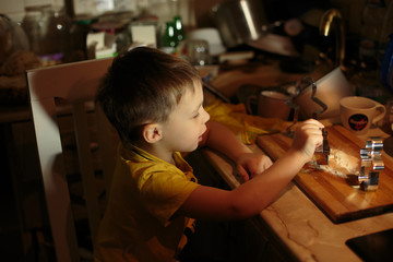 a little boy helps bake cookies