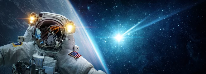 Deurstickers Astronaut in een baan om de aarde tegen de achtergrond van een vallende meteoriet, asteroïde, komeet. Het concept op het thema apocalyps, armageddon, dag des oordeels, Elementen van deze afbeelding geleverd door NASA. © Tryfonov