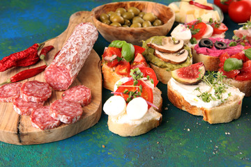 Assorted bruschetta with various toppings. Appetizing bruschetta or crudo crostini. Variety of small sandwiches. Mix bruschetta with tomatoes and basil