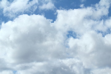 Clouds in the blue sky at sunset or dawn backlit by the sun. Place for text and design.