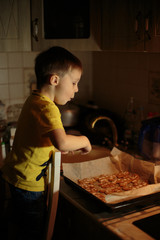 a little boy helps bake cookies