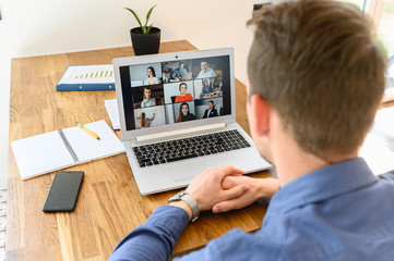 Webinars, online conference, video meeting. A businessman is using app on laptop for video connect...