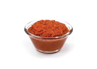 Bowl with red pesto isolated on white background. Bowl of traditional Italian red pesto isolated on white from above.