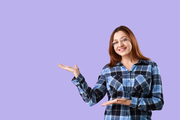 Portrait of beautiful woman showing something on color background