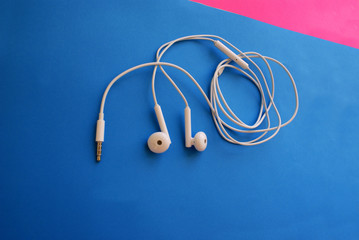 Headphones for a smartphone on a bright background, modern technology.