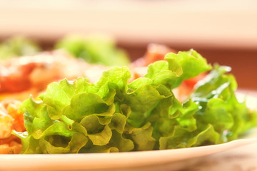 Soft focus. Dining table in a rural house in the kitchen. On the tablecloth is a plate with breakfast. Lettuce leaves, ham, eggs.