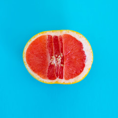 Half of grapefruit on a blue background.
