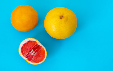 Top view ripe whole grapefruit and half on a blue background.