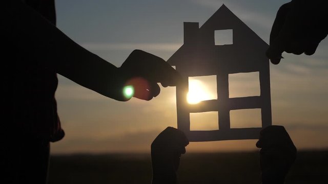happy family construction house teamwork concept. Mom daddy and son holding home a paper house in his hands at sunset silhouette sunlight. life lifestyl symbol ecology video . boy and girl,man hold