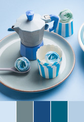 Still life with blue coffee maker, cup and flower on abstract background. Color swatch