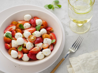 Salad with mozzarella, strawberries and cherry tomatoes. Healthy eating Vegetarian salad