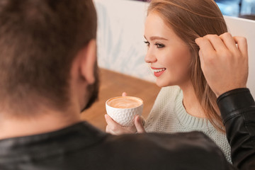 Young couple drinking coffee in cafe