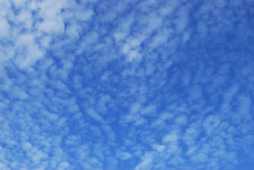
delicate patterns of white clouds in the blue sky