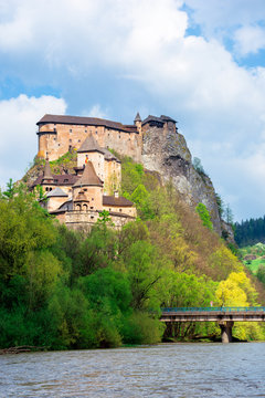 medieval orava castle on the hill. beautiful springtime scenery in dappled light above the river. popular travel destination of slovakia