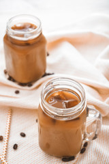 Mason jar of tasty iced coffee on table