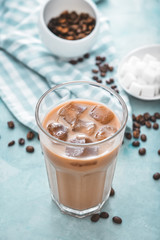 Glass of tasty iced coffee on color background