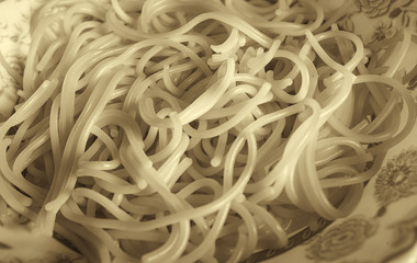 Breakfast at home on the forge. On a plate is vermicelli - Italian spaghetti. Photographed close-up. Color image. Horizontal frame. Black and white image, sepia, soft contrast.
