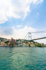 istanbul, turkey - AUG 18, 2015: fatih sultan mehmet bridge above the bosphorus. beautiful cityscape of historical area observed from the water on a sunny summer day. calm weather with fluffy clouds