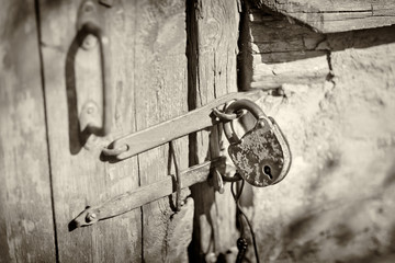Soft focus. Countryside. The door is the entrance to the barn. Locked on an old retro castle. Horizontal frame. Black and white image. Sepia. Picture taken in Ukraine, Kiev region.