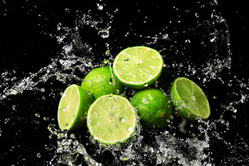 Fresh limes with water splashes on dark background © Pixel-Shot