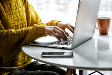 Woman hands working with laptop at table typing