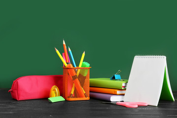 Holder with stationery on table in classroom