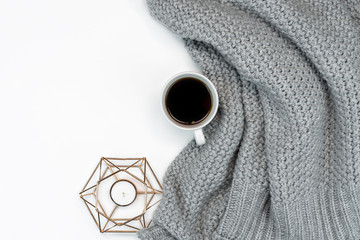 Flatlay of gray knitted sweater, and coffee. and candle. Copy space. Cosy weekend in cold weather