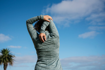 young woman stretching shoulders in nature