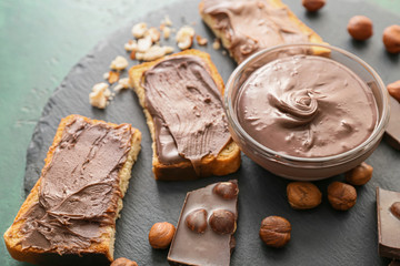 Fresh bread and chocolate paste on slate plate, closeup